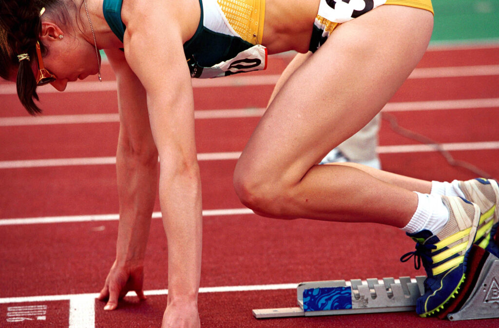 Blocchi di partenza appoggiati sulle corsie rosse di una pista di atletica