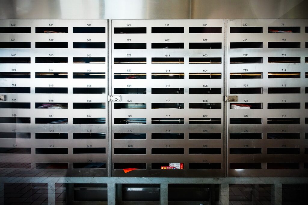 Fila di cassette della posta metalliche nell'ingresso condominiale di un edificio