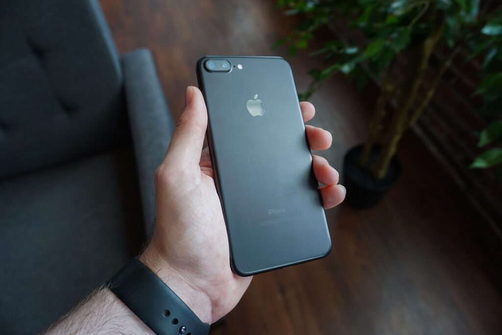 Mano che tiene uno smartphone acceso con una conversazione di gruppo aperta sullo schermo