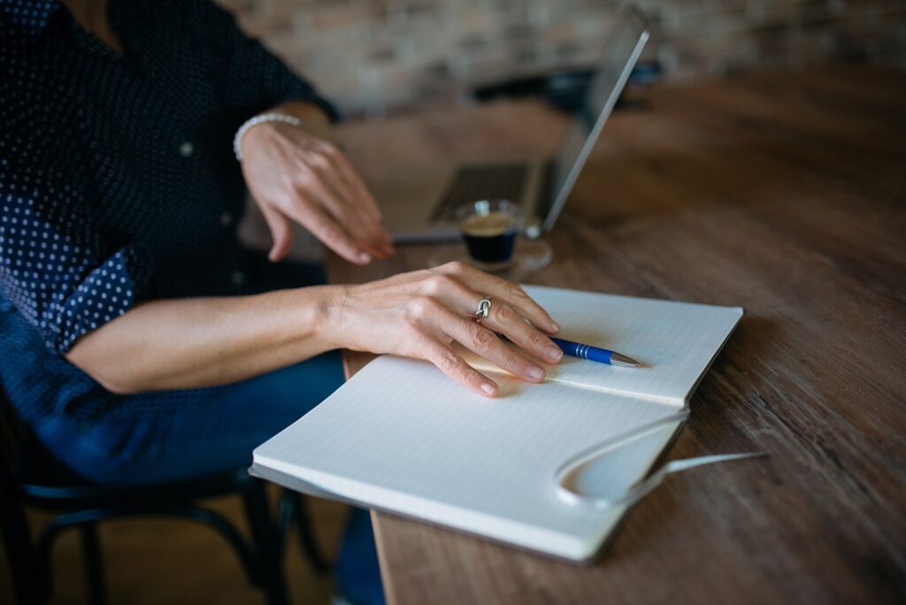 Quaderno aperto con poche righe scritte a mano e una penna appoggiata accanto