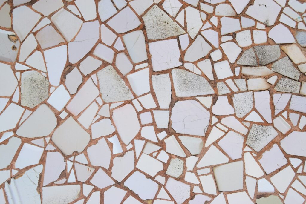 Tazza di ceramica rotta appoggiata su un piano con i frammenti raccolti accanto