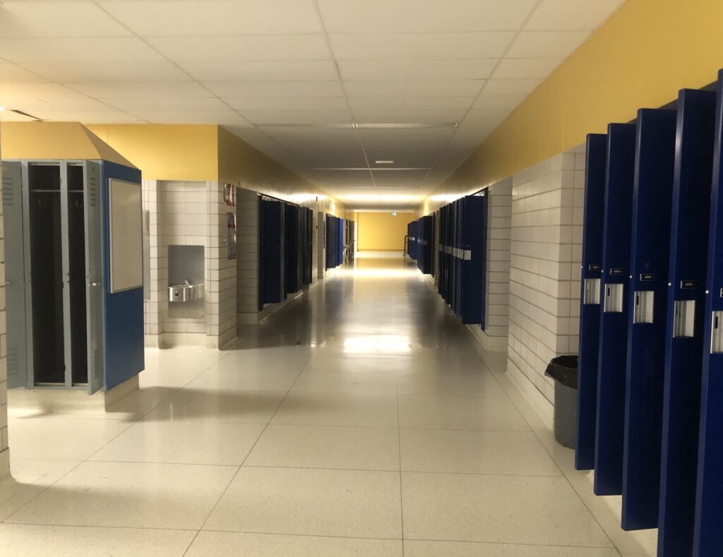 Corridoio scolastico con sedie allineate in attesa fuori da un'aula