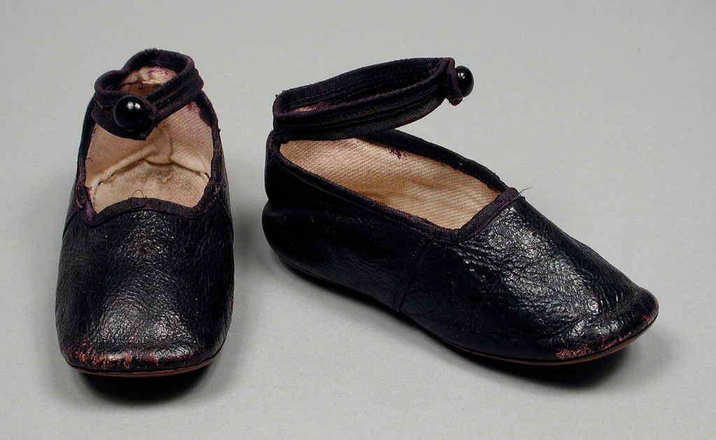 Scarpe da bambino lasciate nell'ingresso di casa accanto a uno zaino aperto